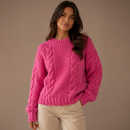 Caimento amplo do suéter de tricô pesado feminino mostrando o design moderno com mangas volumosas e movimento na cor rosa