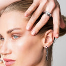 Elegant woman with minimalist luxury fashion, wearing a sterling silver 925 mosaic ring, soft cashmere sweater, neutral tones, natural sunlight through a large window, focus on the ring and hand, luxury feminine lifestyle, premium jewelry advertising photography, ultra realistic, highly detailed, 8k