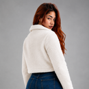 Jaqueta sherpa cropped feminina na cor branca Anabeaz, casaco de pelúcia soft curto com zíper frontal para look de inverno feminino estilo cozy e streetwear chic.Jaqueta teddy Sherpa Cropped Feminina Anabeaz™